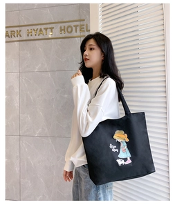 Detail of black canvas tote bag with cartoon girl illustration and Nice Day print