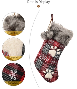Detail view of plaid pet Christmas stockings with plush trim, paw prints and snowflakes
