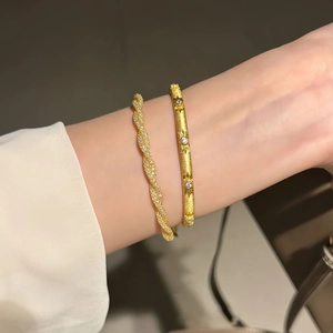 Detail view of gold-plated bracelet set with twisted zircon chain and starburst engraved cuff