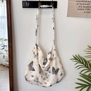 Macro shot of large canvas hobo bag with butterfly print and raw fringe edge detail