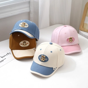 Detailed view of baby baseball caps with bear embroidery and color blocking panels