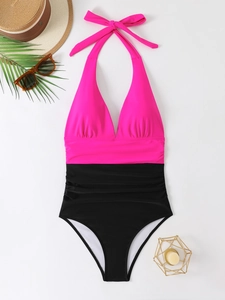 Dettaglio del costume da bagno bicolore rosa e nero con scollo all'americana e pieghe