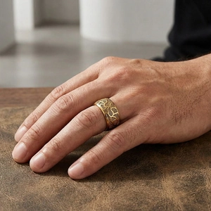 Detail of vintage mens wide gold stainless steel ring with intricate embossed patterns