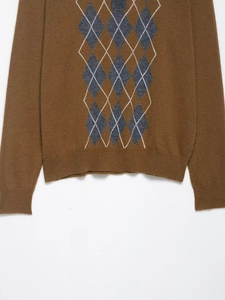 Close-up of brown polo knit sweater with blue argyle pattern and ribbed cuffs detail