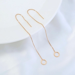 Elegant long minimalist threader earrings with gold circle pendants on white silk