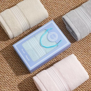 Luxury cotton towel gift set in beige, gray, pink, and blue within an elegant blue box