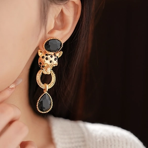 Close-up of vintage leopard head drop earrings with black stones and gold plating