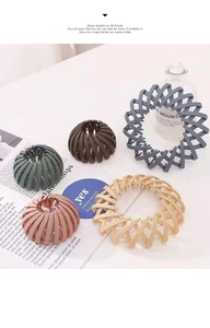Detail view of bird nest hair clips in various Morandi colors showing foldable structure