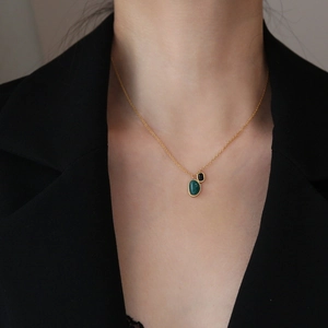 Minimalist gold necklace with green and black agate double pendants on professional attire