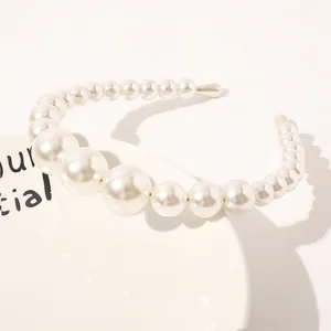 Macro detail of elegant gradient white pearls on a gold metal headband base