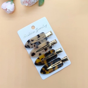 Detailed set of four tortoiseshell resin hair clips with golden metal duckbill grips
