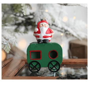 Detail of a festive Santa Claus riding a green miniature train carriage ornament