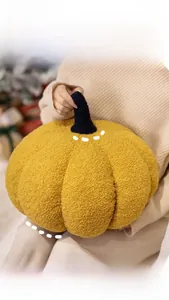Detail of warm yellow pumpkin pillow in soft teddy fleece for autumn home decor