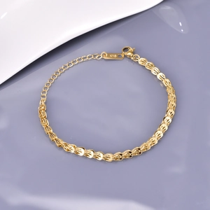 Detailed macro view of 18k gold braided chain bracelet with secure lobster clasp