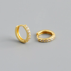 Macro detail of gold S925 sterling silver hoop earrings with inlaid cubic zirconia