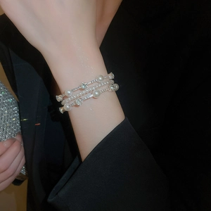 Macro view of multi-layer bracelet with white pearls and sparkling diamonds on silver chain