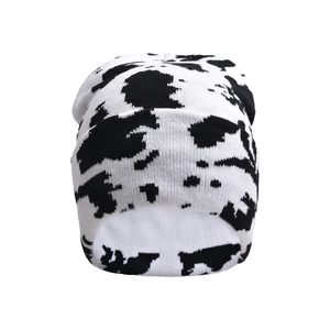 Close-up of thick cow pattern knit beanie with warm white lining for winter
