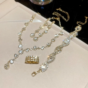 Luxe gold necklace bracelet earring and ring set with sparkling diamonds on display