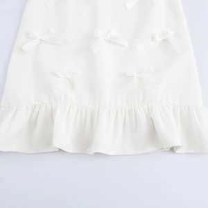 Robe courte blanche sans manches avec nœuds 3D et détails de l'ourlet à volants