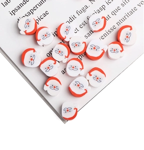 Detailed view of Santa Claus polymer clay beads scattered on an open book for DIY jewelry