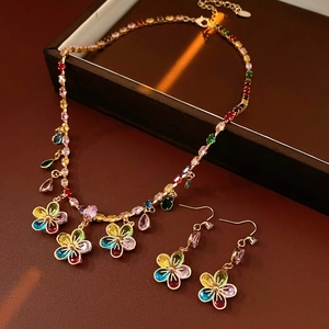 Luxurious gold flower jewelry set with colorful zircon stones on black leather base