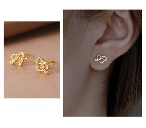Macro detail of S925 silver heart stud earrings with cubic zirconia and gold plating