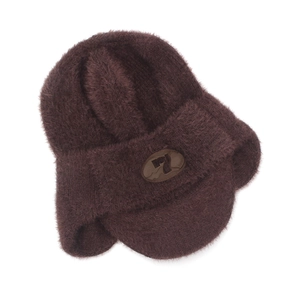 Détail d'un bonnet en tricot marron foncé avec protège-oreilles et emblème en cuir poli