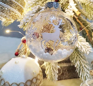 Detail of 8cm transparent Christmas ball with reindeer print and pine cone filling