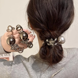 Close-up of spiral hair ties with metallic pearl and rhinestone star charm details