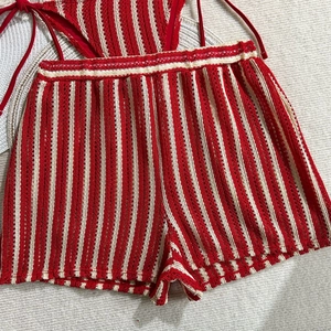 Detailed macro view of crochet knit texture and red vertical stripes on beach shorts