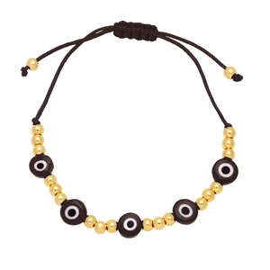 Detail of bohemian evil eye woven bracelet with gold beads and adjustable brown cord