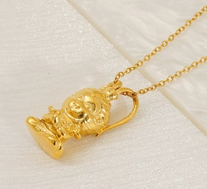 Detail of a 3D gold-plated cartoon rabbit pendant with a fine link chain on white texture