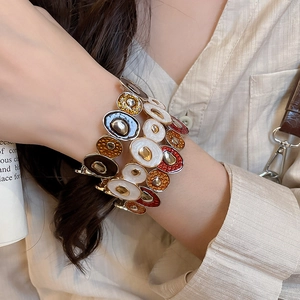 Detail of artistic elastic enamel bracelet with colorful irregular spliced metal charms