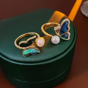 Elegant gold butterfly ring with freshwater pearls and zircon on a green jewelry box