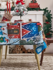 Close-up of festive Christmas tablecloth with Santa Claus and snowy cottage illustration