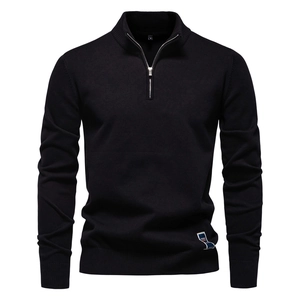 Détail d'un pull en maille noire avec demi-fermeture éclair et poignets côtelés
