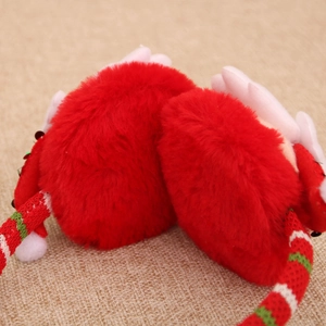 Close-up of festive red plush Christmas earmuffs with striped headband on rustic background