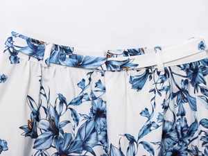 Detailed close-up of blue floral print on white fabric with invisible zipper and belt