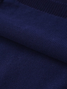 Close-up of premium dark blue fine knit wool fabric texture with ribbed edge detail