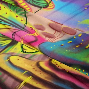 Macro close-up showing soft vibrant fabric texture and colorful mushroom tapestry print