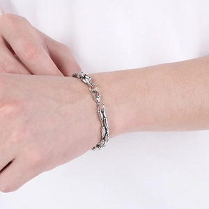 Detail of silver bamboo link chain bracelet on wrist showing metallic texture and clasp