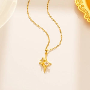 Detail of gold starburst necklace featuring zircon inlay and unique flat chain links