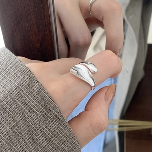 Close-up of a minimalist irregular silver ring on a finger with artistic mirror reflection