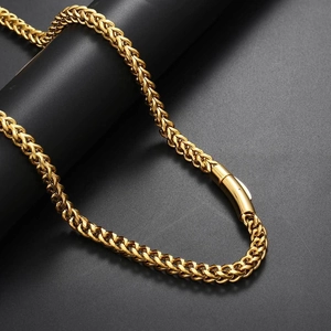 Macro detail of golden Spiga chain necklace with minimalist cylindrical clasp