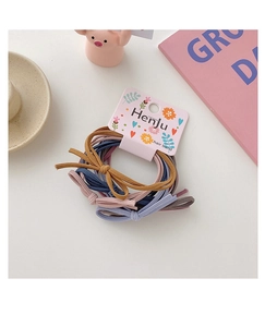 Detailed view of elastic bow hair ties in multi-color pastel tones on pink card packaging