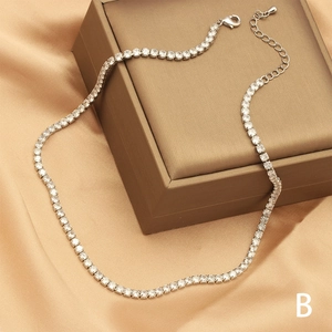 Detail of silver-tone zircon tennis necklace with claw-set stones on satin backdrop