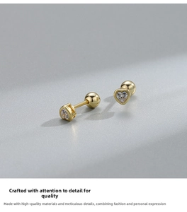 Macro view of S925 silver heart screw-back stud earrings with gold finish and zircon