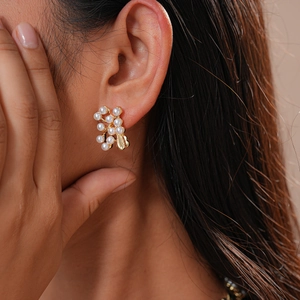 Detail of vintage flower and leaf cluster earrings with white pearls and gold base