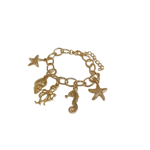 Golden ocean theme charm bracelet featuring starfish, conch, and seahorse charms