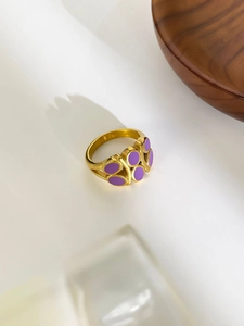 Top view of gold ring featuring multiple purple oval enamel inlays in geometric pattern